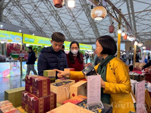 Bà Phạm Thị Việt Hà - Phó Giám đốc Công ty TNHH Trà và Đặc sản Tây Bắc giới thiệu các sản phẩm trà đến khách tham quan.